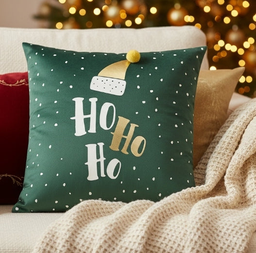 Green pillow with 'Ho Ho Ho' text and Santa hat design on a black background