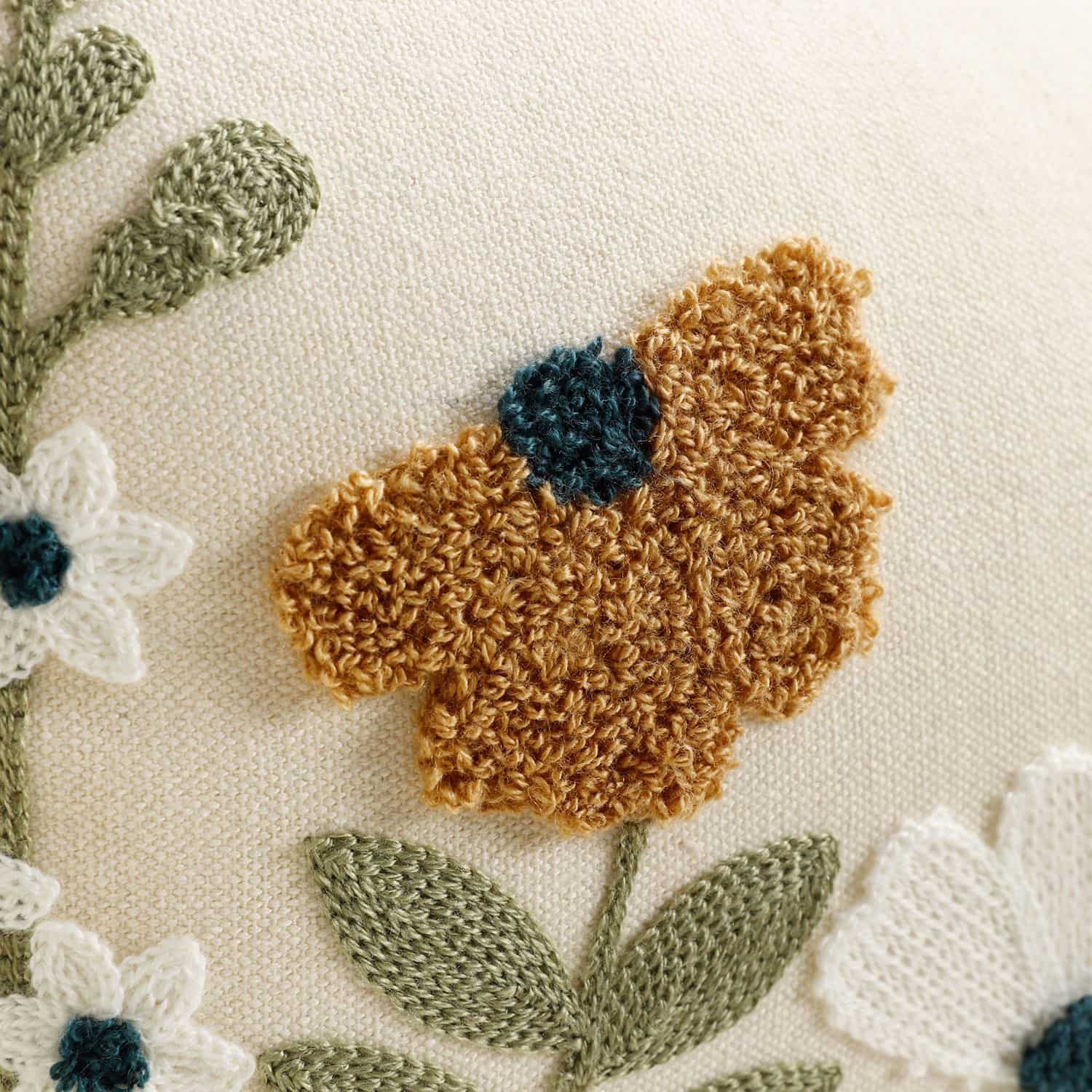 Close-up of floral embroidery and butterfly detail on cushion cover