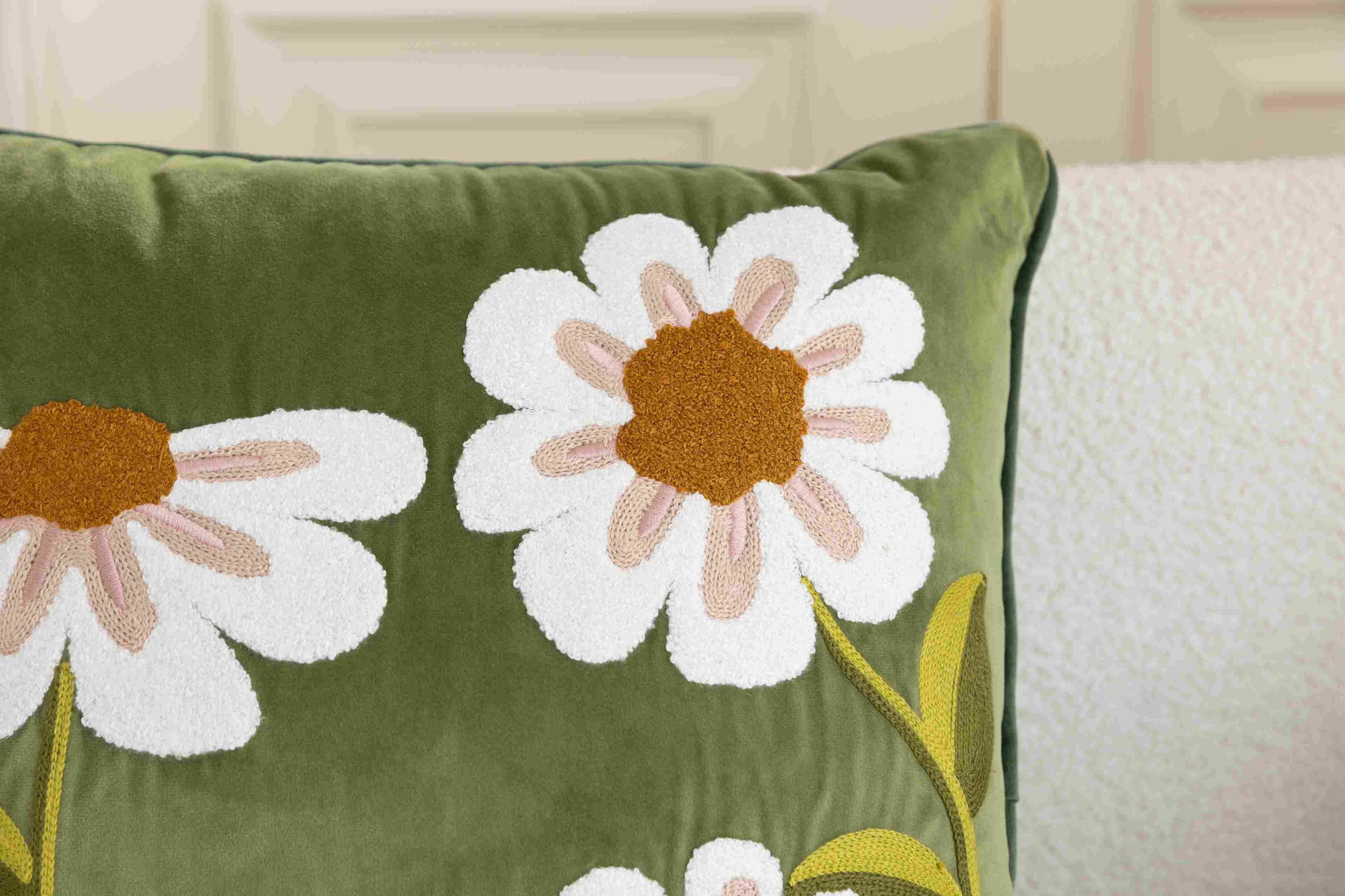 Close-up of daisy embroidery on navy velvet cushion cover