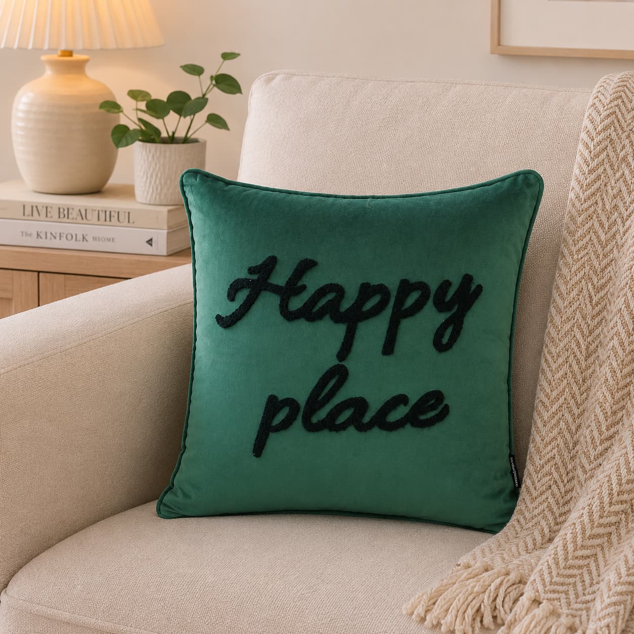 Teal green Happy Place velvet cushion cover 45x45cm with black tufted lettering on a beige sofa.