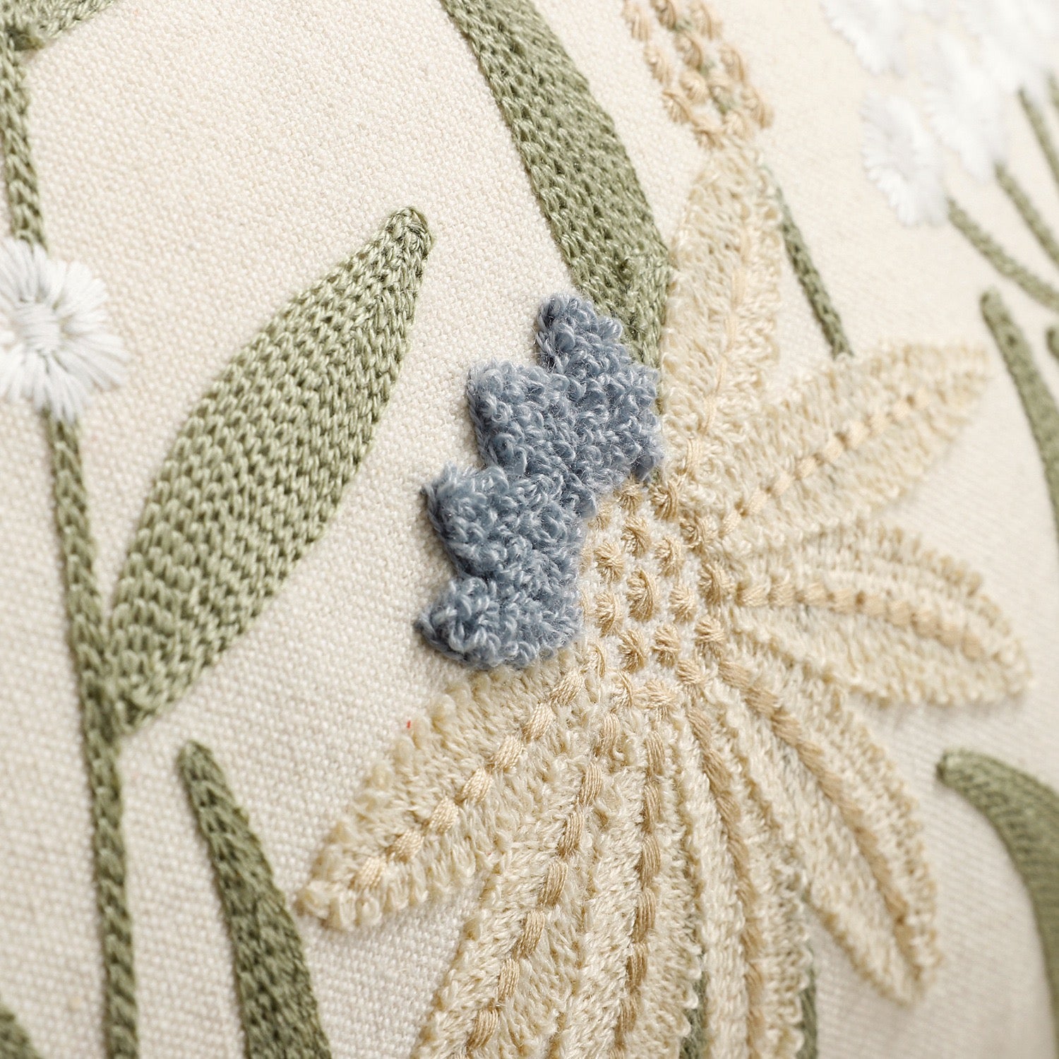 Close-up of botanical embroidery on meadow cushion cover